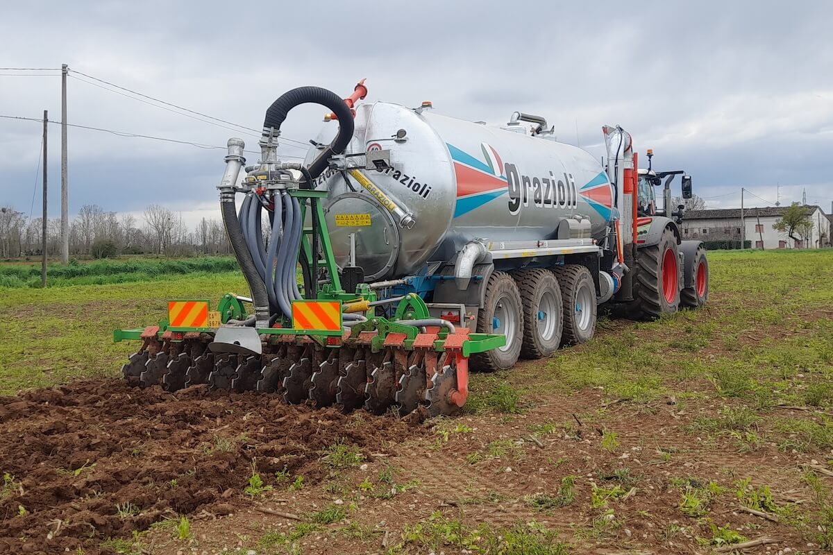 Carrobotte a tre assi con dischiera pieghevole da 4 metri impegnato nell'interramento dei reflui zootecnici